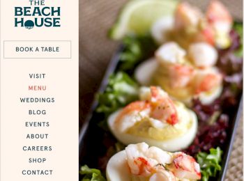 A food image showing deviled eggs topped with shrimp on a bed of greens. "The Beach House" restaurant name with a menu and booking options is visible.